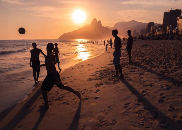 Rio de Janeiro, Brasil. Jovens jogando bola na praia durante o pôr do sol