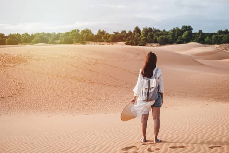 Viajante jovem andando em dunas de areia vermelha no Vietnã, conceito de estilo de vida de viagem