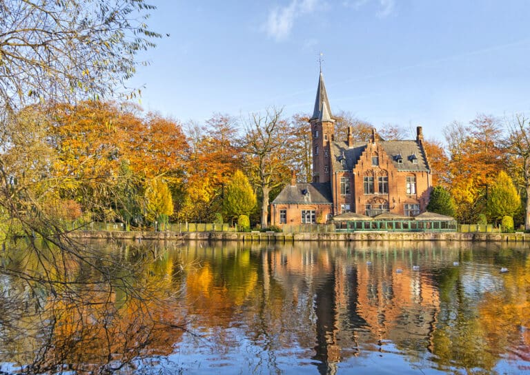 Edifício de estilo flamengo refletindo no lago Minnewater, Bruges